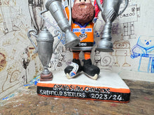 Load image into Gallery viewer, Sheffield Steelers cartoon character tansey 6 with medals / celebrating with removable trophies and Grand Slam base
