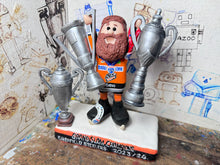 Load image into Gallery viewer, Sheffield Steelers cartoon character tansey 6 with medals / celebrating with removable trophies and Grand Slam base
