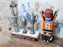 Load image into Gallery viewer, Sheffield Steelers cartoon character tansey 6 with medals / celebrating with removable trophies and Grand Slam base
